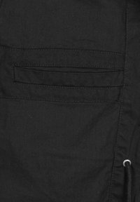 Black fabric with a smooth texture featuring a horizontal pocket and a drawstring detail on the side. Simple, functional design.