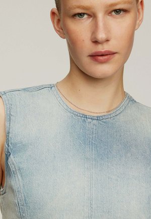 Vestido de denim en azul claro, diseño sin mangas con cuello redondo, que presenta detalles de costura visibles y una superficie ligeramente texturizada.