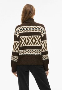 Rjav pleten pulover z visokim ovratnikom, na hrbtni strani z geometričnim kremno-črnim vzorcem. Debel in teksturiran material.