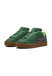 Sneakers verdi con tomaia testurizzata, dettagli viola e suola in gomma. Presentano lacci verdi e charm a tema sugli occhielli.