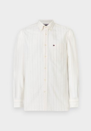 Košela na gombíky s dlhým rukávom v svetlej krémovej farbe z bavlny, s tenkými vertikálnymi pruhmi, náprsného vrecka a malým logom na ľavej strane.