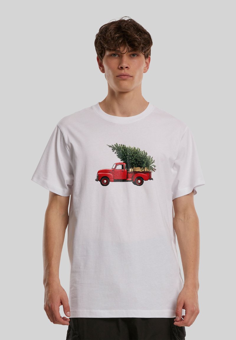 Άσπρο βαμβακερό t-shirt με γραφικό ενός κόκκινου vintage φορτηγού που μεταφέρει ένα πράσινο χριστουγεννιάτικο δέντρο στο πίσω μέρος του, με απλή λαιμόκοψη.