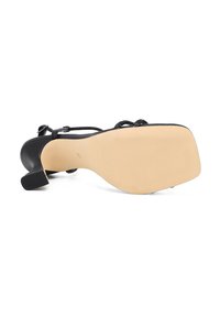 Scarpa nera con tacco alto, punta quadrata e retro testurizzato. Presenta sottili cinturini e una suola in gomma beige con motivo in rilievo.