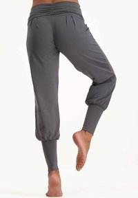 Graue, kurze Hosen aus einem glatten, dehnbaren Stoff; mit gerafftem Bund, schmalen Beinen und elastischen Bündchen an den Knöcheln.