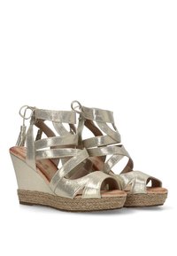 Sandalias de cuña metálicas doradas con tiras entrecruzadas y punteras descubiertas, que cuentan con una plataforma envuelta en yute y un forro interior suave.
