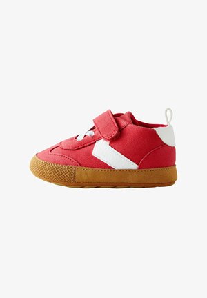 Rote Wildleder-Kinderschuhe mit weißen Lederakzenten, ausgestattet mit einem Klettverschluss, weißen Schnürsenkeln und einer braunen Gummisohle.