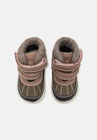 Bottes pour tout-petits marron et rose avec doublure en laine, bandes Velcro et couture blanche. Semelles en caoutchouc avec un bout rond et un col rembourré.