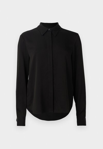 Schwarze Bluse mit langen Ärmeln, spitzem Kragen, verdeckter Knopfleiste und abgerundetem Saum vor einem schlichten weißen Hintergrund.
