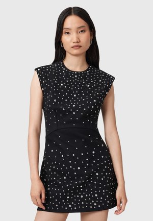 Rochie neagră fără mâneci, cu o siluetă ajustată, decorată cu embellishments metalice într-un model dispersat, având o textură de țesătură netedă.