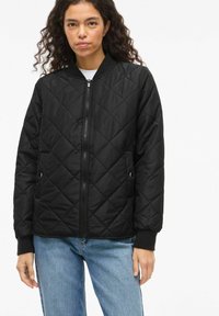 Črna prešita bomber jakna z zadrgo spredaj, rebrastimi manšetami in stranskimi žepi. Gladek material z običajnim prileganjem in klasično silhueto.