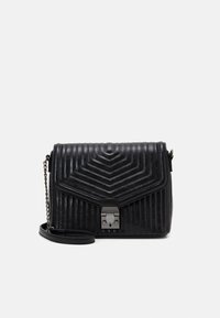 Bolso de mano de cuero negro acolchado con un patrón geométrico, un cierre de metal y una correa de cadena. Forma compacta con una superficie texturizada.