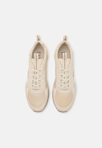 Beige tenisky s prodyšným a hladkým koženým materiálem, šněrováním, poutky na patě a decentním logem na stélce.