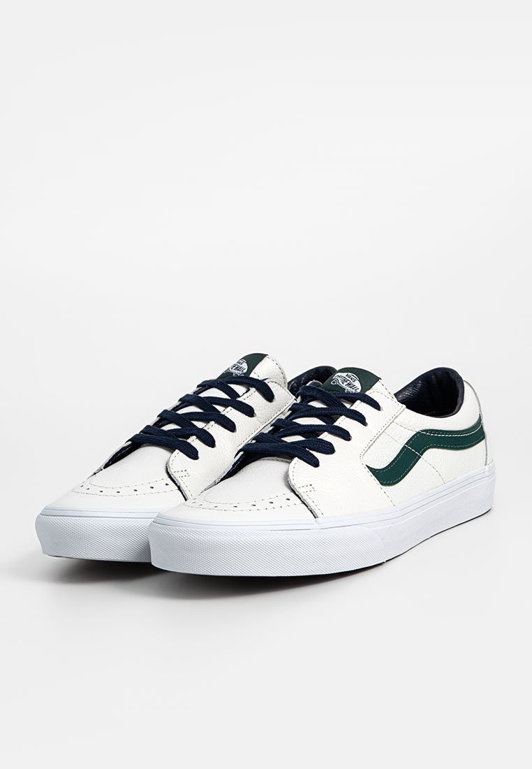 Weiße Sneakers mit grünen Akzenten, Obermaterial aus strukturiertem Leder, marineblaue Schnürsenkel und Gummisohle. Klassisches Low-Top-Design mit sichtbaren Nähten.