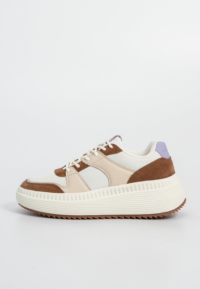 Calzature caratterizzate da una combinazione di materiali scamosciati beige, crema e marrone, insieme a rete. Sole bianco chunky con dettagli testurizzati e un accento viola.