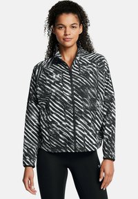 Schwarz-weiße Zip-Jacke mit einem abstrakten Streifenmuster, leichtem Stoff, hohem Kragen und langen Ärmeln.