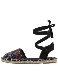 Sandalo espadrilles nero con una zona toe decorata da perline, dotato di una cinghia alla caviglia in tessuto e una suola in juta intrecciata. Cuciture dettagliate lungo i bordi.
