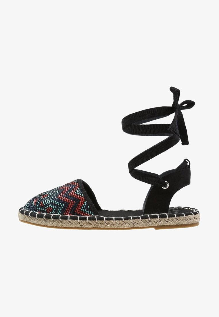 Sandalo espadrilles nero con una zona toe decorata da perline, dotato di una cinghia alla caviglia in tessuto e una suola in juta intrecciata. Cuciture dettagliate lungo i bordi.