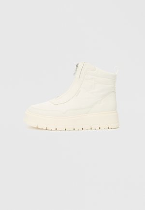 Hvide højtop sneakerstøvler med en sidelukning, tyk sål med mønster og en pull-tab bagpå, vist fra siden på en ensfarvet baggrund.