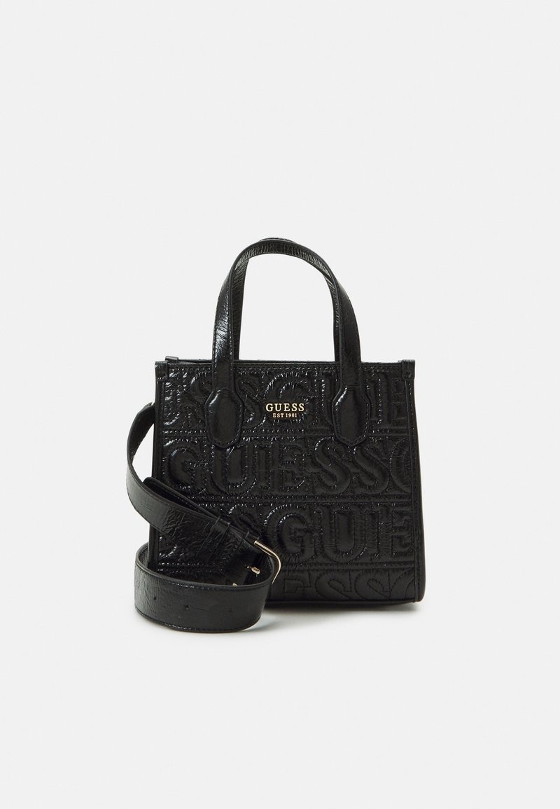 Sac à main Guess en cuir noir texturé avec motif logo embossé, deux poignées supérieures et une bandoulière amovible avec boucle.