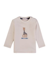 Maglietta a maniche lunghe color crema con grafica di una giraffa con pois blu e testo "SOPHIE LA GIRAFFE" sottostante. Materiale in cotone morbido.