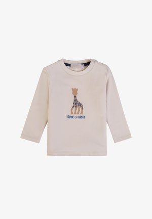 Maglietta a maniche lunghe color crema con grafica di una giraffa con pois blu e testo "SOPHIE LA GIRAFFE" sottostante. Materiale in cotone morbido.