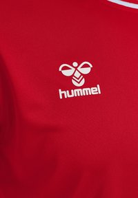 Röd sporttröja gjord av slätt tyg, med en vit logotyp av en stiliserad bi och märkesnamnet "hummel" på bröstområdet.
