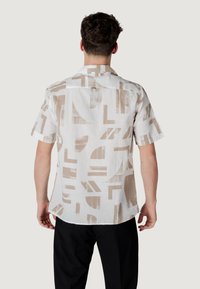 Korte mouw shirt van lichtgewicht stof met een abstract beige en witte geometrische patroon, met een rechte zoom en kraag.