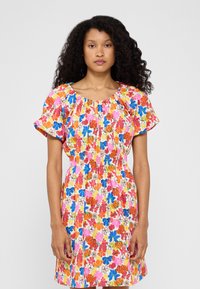 Blomsterkjole med smocket midje, korte pufferm og rund hals. Fargene inkluderer rosa, blå, oransje og gul.