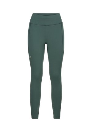 High-waisted, volledig bedekkende leggings in donker groen stof. Gladde textuur met platte naden en een subtiel logo op het onderbeen.
