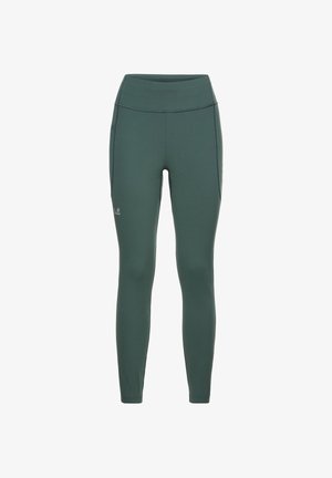 High-waisted, full-length leggings in dark green fabric. Smooth texture with flat seams and a subtle logo on the lower leg.