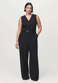 Black pinstripe jumpsuit with a deep V-neck, sleeveless design, front buttons, belted waist, and wide-leg trousers. Smooth fabric texture.