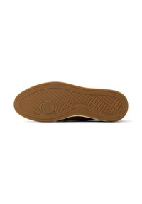 Rubber sneaker sole with a textured, gum-brown surface. Features a circular logo at the center and horizontal/vertical grooves for grip.