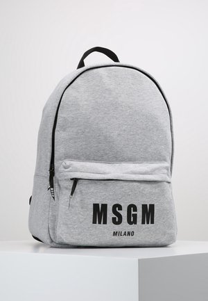 Světle šedý látkový batoh s černými zipy a nápisem "MSGM MILANO" výrazným černým písmem na přední kapse.