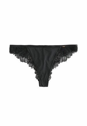 Black thong made of smooth fabric with lace trim on the sides. Features ruffled edges and a small logo tag on the waistband.