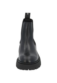 Botín negro de cuero con paneles laterales elásticos, punta redondeada y suela de goma texturizada. Cuenta con una pestaña en la parte posterior para facilitar el calzado.