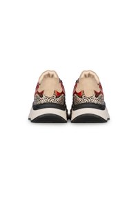 Sneaker mit einem strukturierten beige-schwarzen Obermaterial, das rote metallische Akzente aufweist, sowie einer gepolsterten weißen Sohle. Gerundete Spitze und sportliches Design.