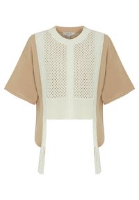 Top corto a maniche corte con corpo in cotone beige e parte frontale bianca lavorata a maglia, caratterizzata da un motivo a cavo testurizzato e dettagli in frange.