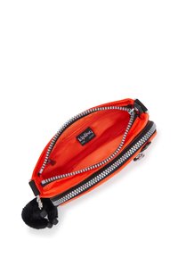 Busta in nylon arancione con zip argento, accessori neri e un portachiavi a pom-pom. L'interno presenta una fodera arancione brillante e un'etichetta del marchio.