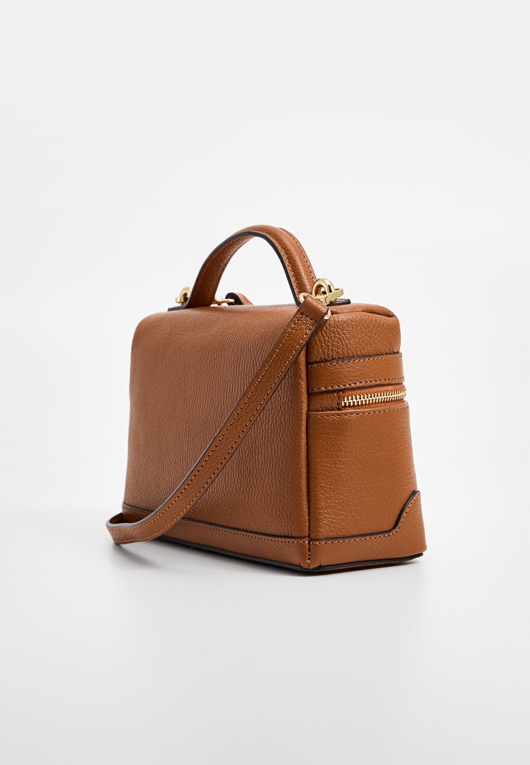 Sac à main en cuir marron avec une forme structurée, une finition texturée, une bandoulière amovible et une petite poche zippée sur le côté.