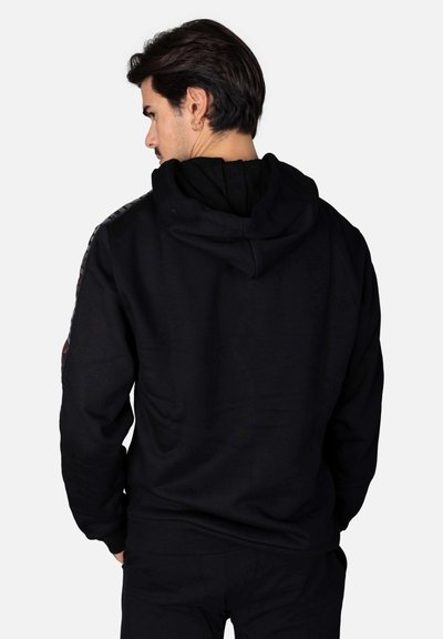 Felpa nera con cappuccio e coulisse, caratterizzata da dettagli decorativi sulle spalle. Il tessuto sembra morbido, con una vestibilità comoda e polsini a costine.