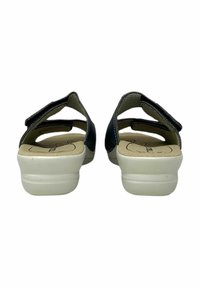 Sandali neri con cinturini regolabili, suole in gomma bianche, suole interne testurizzate e retro aperto. Caratterizzati da materiale perforato per la traspirabilità.
