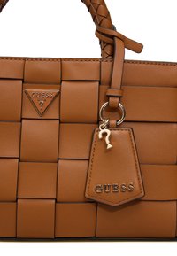 Borsa a tracolla intrecciata marrone con superficie texturizzata, presenta un logo in metallo, un portachiavi rimovibile e manici intrecciati. Design piccolo e strutturato.