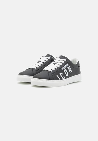 Sneakers in pelle nera con lacci bianchi, dotati di suola piatta e un audace marchio "ICON" sul lato. Texture liscia e design a bassa altezza.