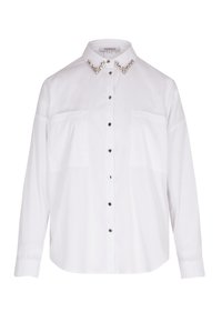 Camisa blanca de botones con cuello extendido adornado con acentos similares a cristales, dos bolsillos en el pecho y mangas largas. Textura de tela suave.