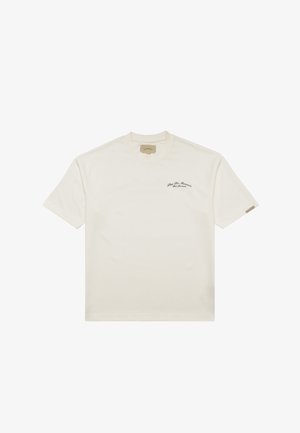 Cremefarbiges T-Shirt mit kurzen Ärmeln, rundem Ausschnitt und kleinem schwarzem Text "Pine De Monaco" auf der linken Brust.