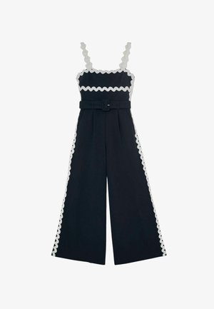 Salopetă largă bleumarin cu margine ondulată albă, bretele fără mâneci, decolteu pătrat și curea asortată în talie.