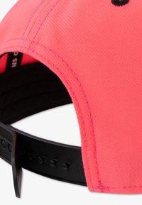 Ροζ καπέλο μπέιζμπολ με υφασμάτινη υφή, κυρτή γείσο και μαύρο ρυθμιζόμενο κούμπωμα snapback με πολλαπλές τρύπες για ρύθμιση μεγέθους.