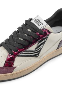Sneaker in pelle bianca con lacci neri, accenti in vernice bordeaux, dettaglio a stampa zebra e suola beige. Presenta un'etichetta sulla linguetta.