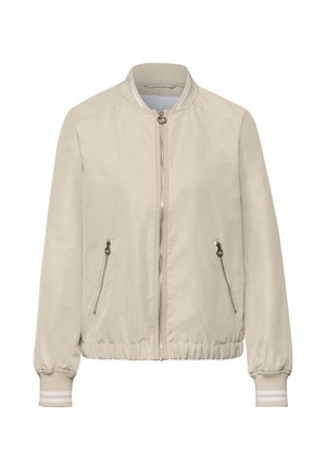 Hellbeige Bomberjacke mit Frontreißverschluss, zwei seitlichen Reißverschlusstaschen, geripptem Kragen, Bündchen und Saum mit weißen Streifen.