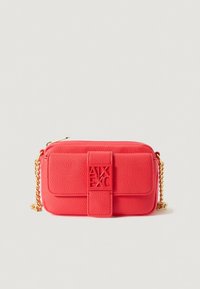 Sac bandoulière en cuir rouge texturé avec une chaîne dorée, doté d'un rabat avant et d'un détail logo. Forme rectangulaire compacte.